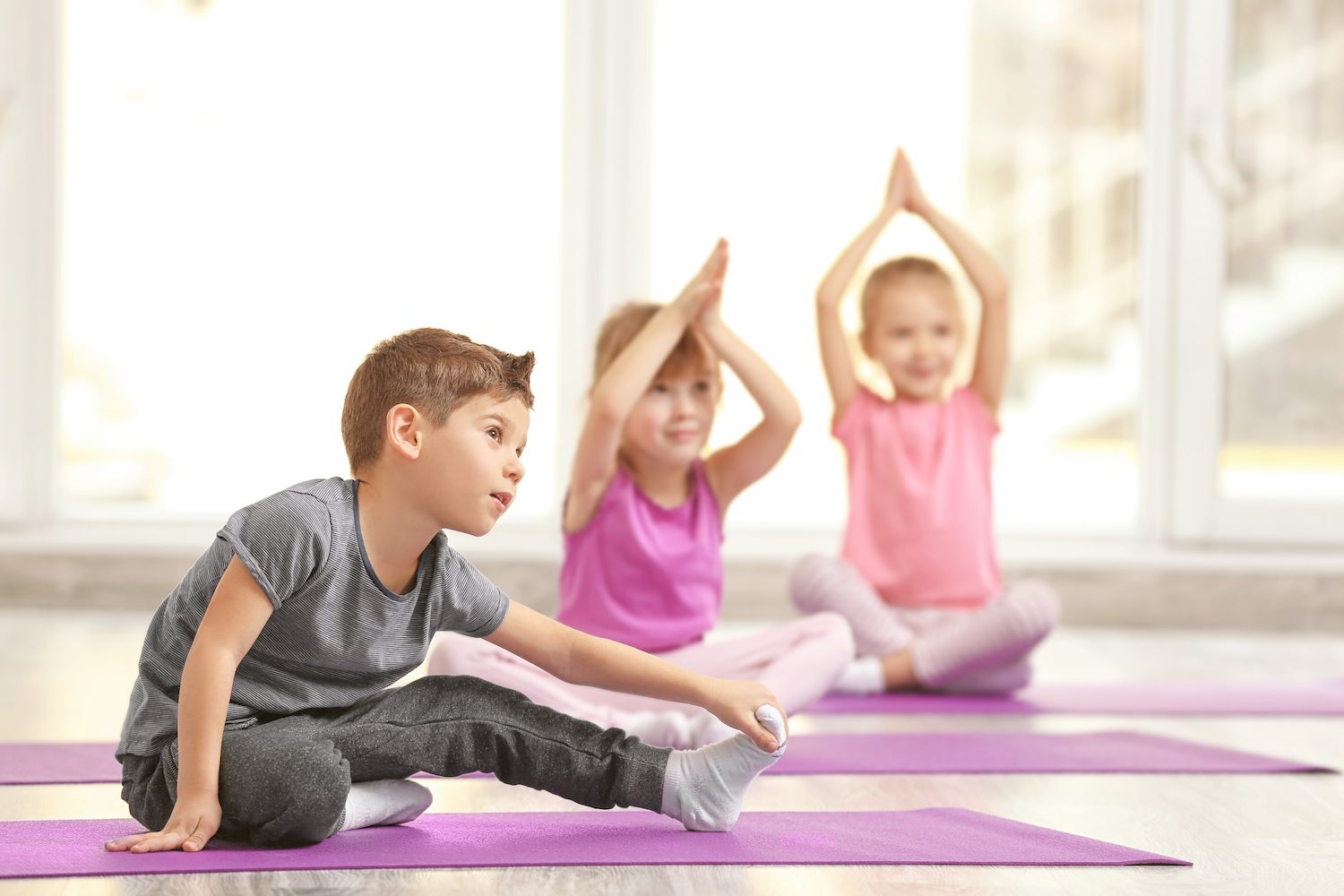 Children practicing yoga in a bright room.