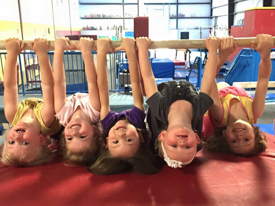 Some small girls hanging upside down